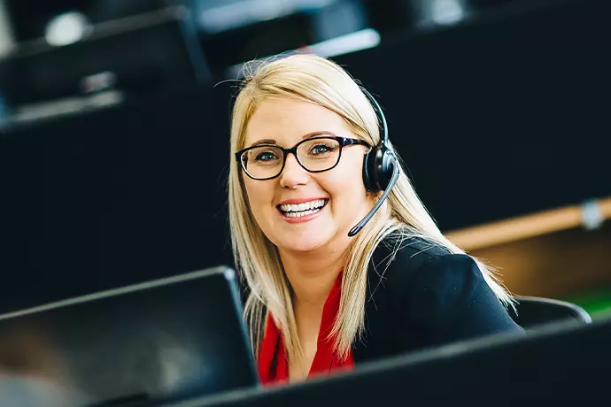 Jo from our IT support team sat at desk smiling